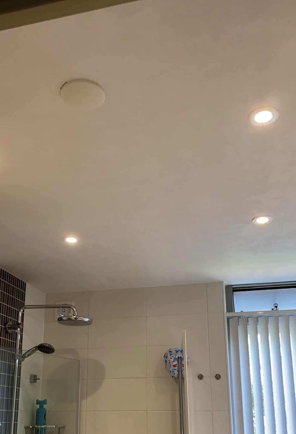 Badkamerplafond met ingebouwde LED-spots boven een inloopdouche